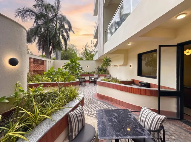 Courtyard at sunset with curved terracotta seating and palms